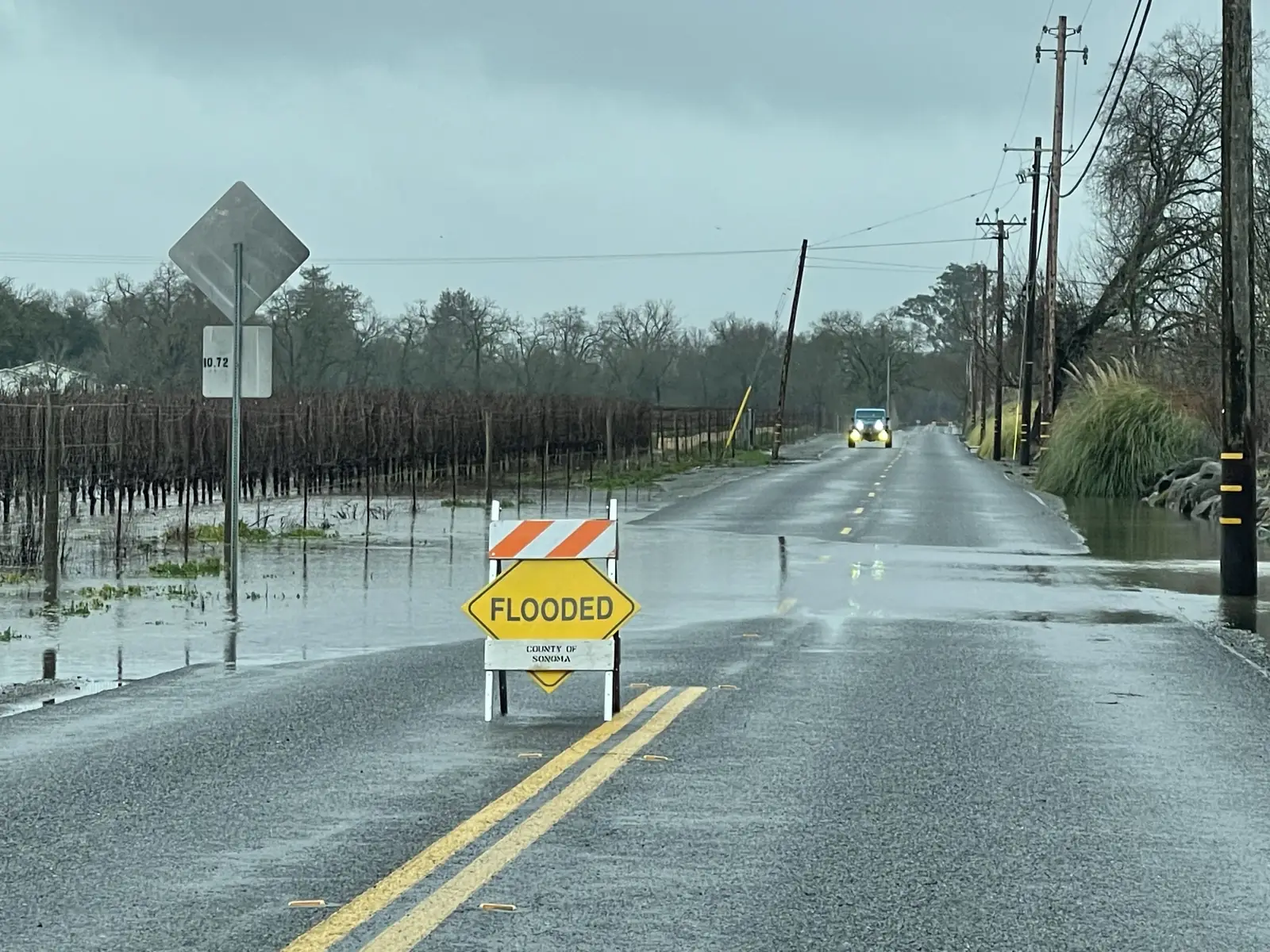 Flooded residential street with standing water over the roadway, illustrating flood damage cleanup needs in Lancaster, CA