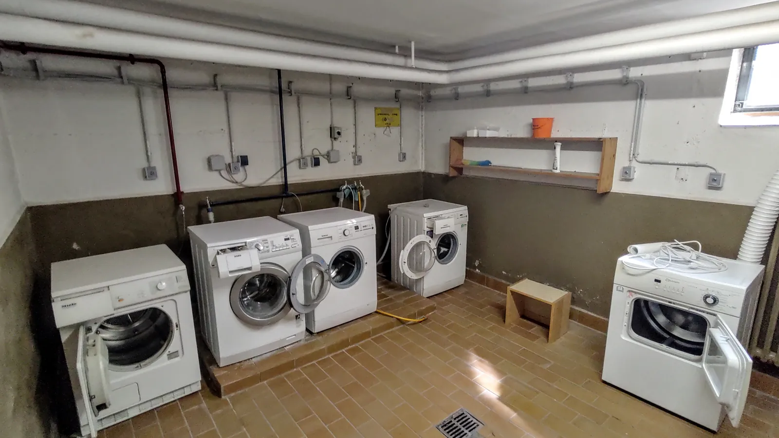 Row of washing machines in a laundry room, related to appliance leak cleanup in Lancaster, CA