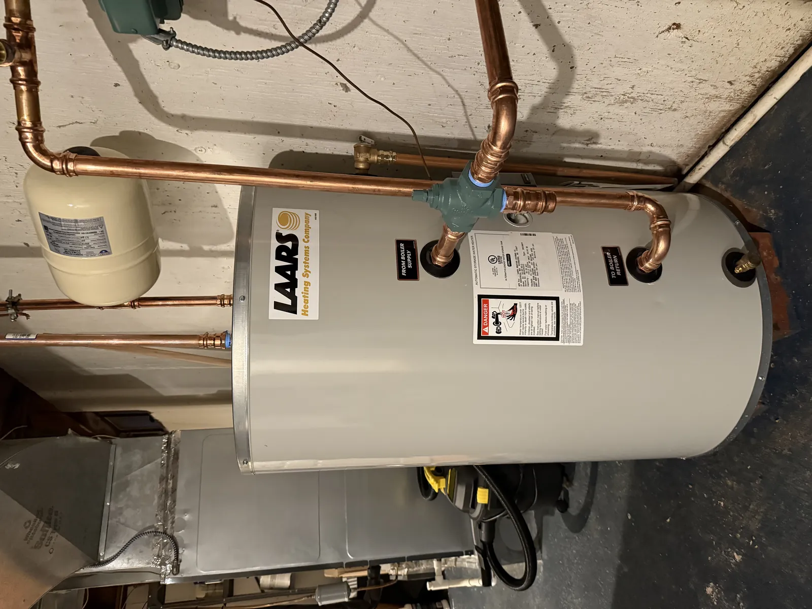 Newly installed residential water heater in a home utility area, related to water heater leak cleanup in Lancaster, CA